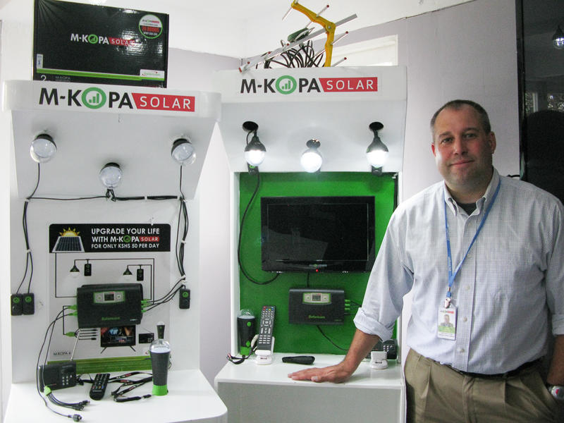 Chad Larson with M-KOPA solar light and solar TV systems.